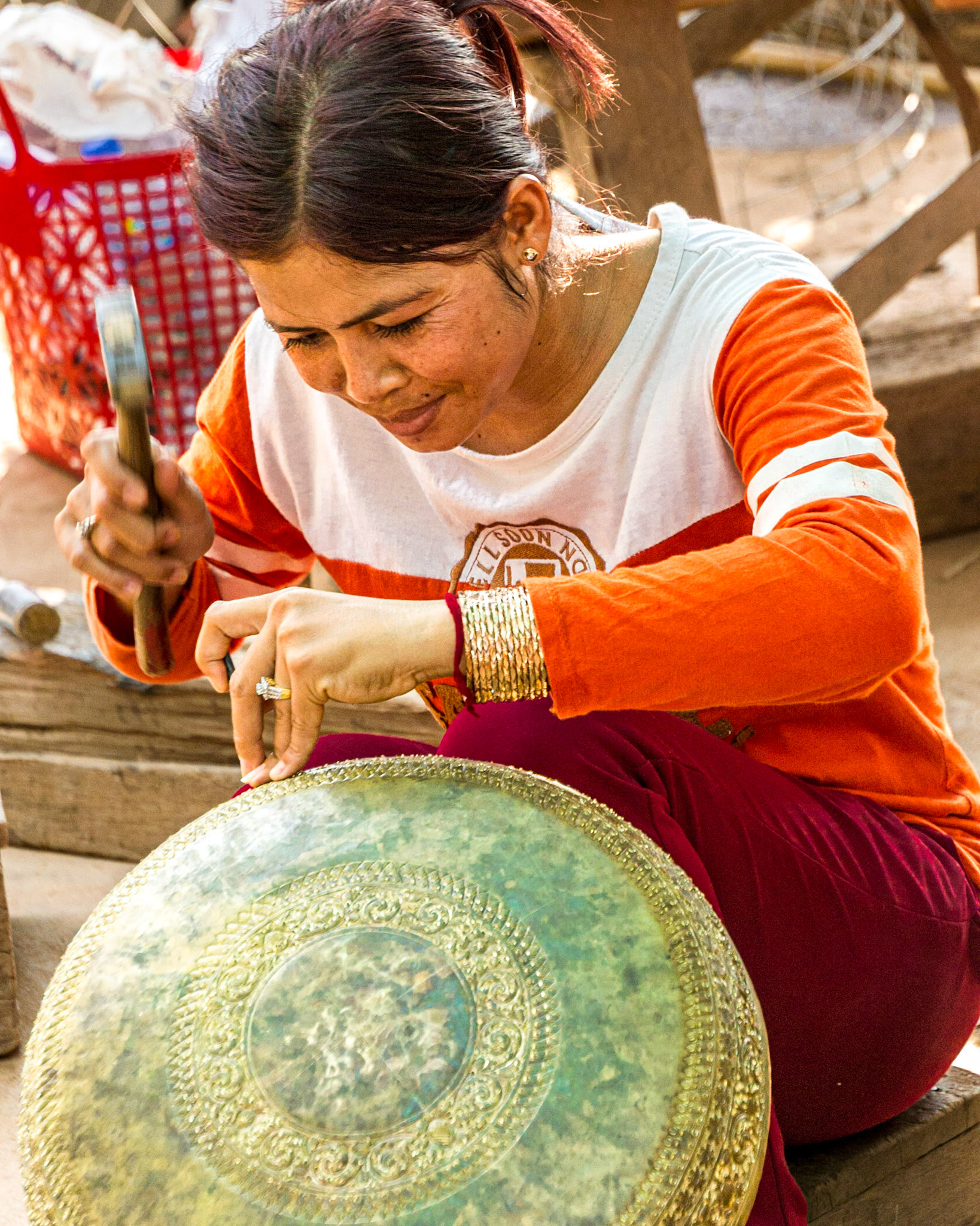 Local silversmith artisan skillfully decorates a silver platter by hand.