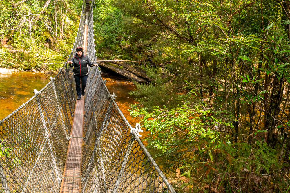 Cheryl negotiating the swing bridge over the Franklin River.