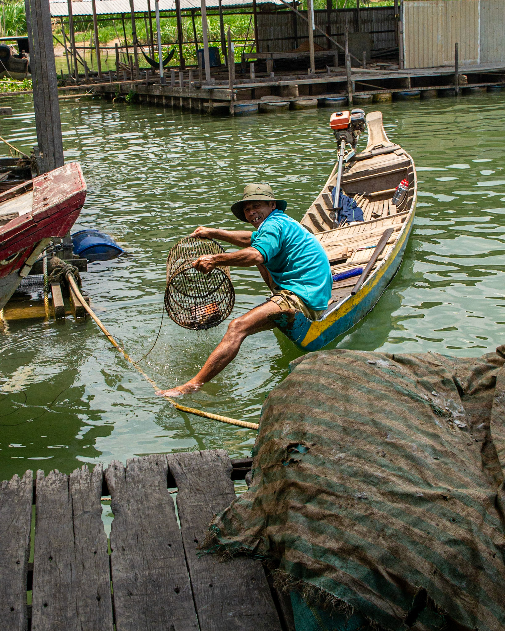 A local fisherman hoping to trap wayward fish escaping from the adjacent the pens .