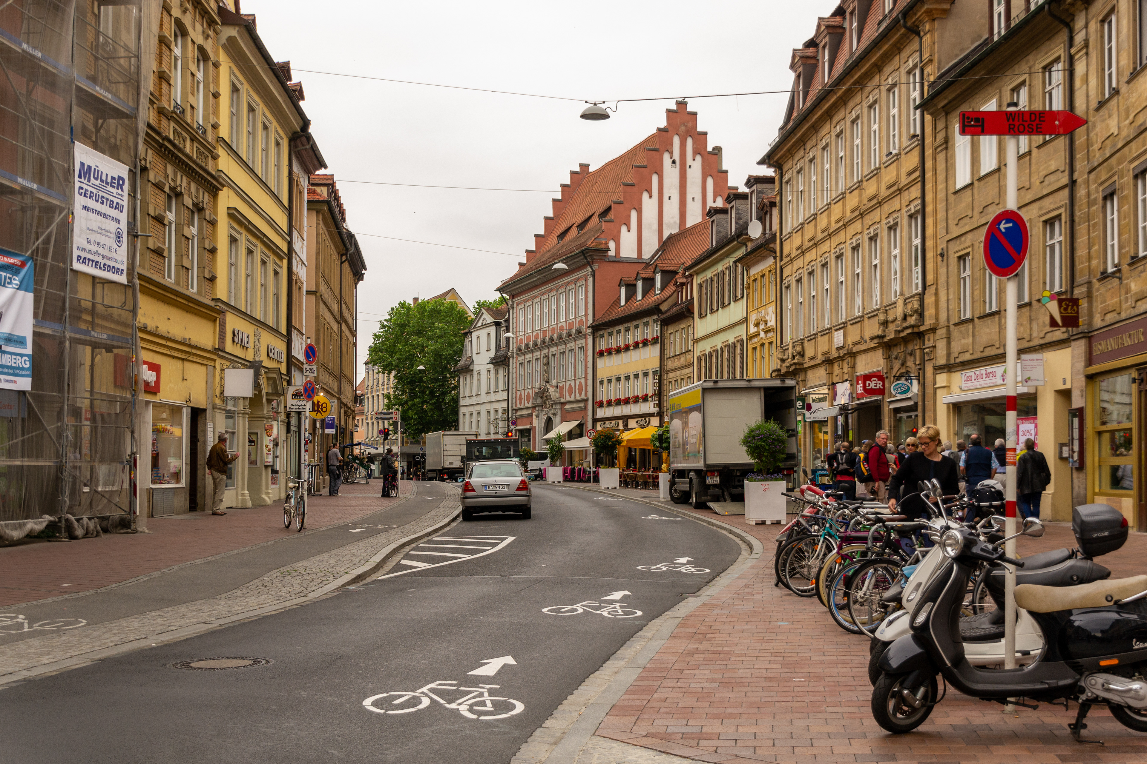 Medieval buildings line the streets of Bamberg juxtaposed to modern day vehicles.