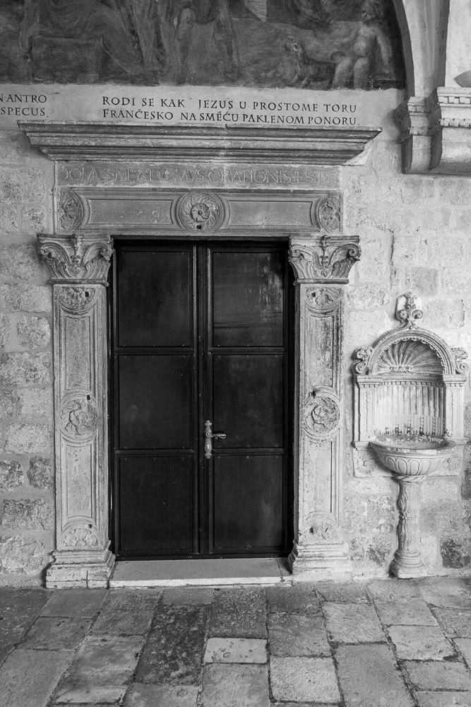 Franciscan Monastry Cloisters - drinking fountain beside panelled doors.