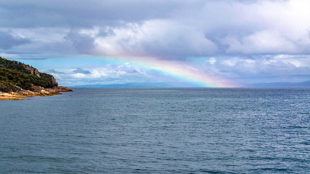A rainbow lights up in the distance as the showers clear from the bay.