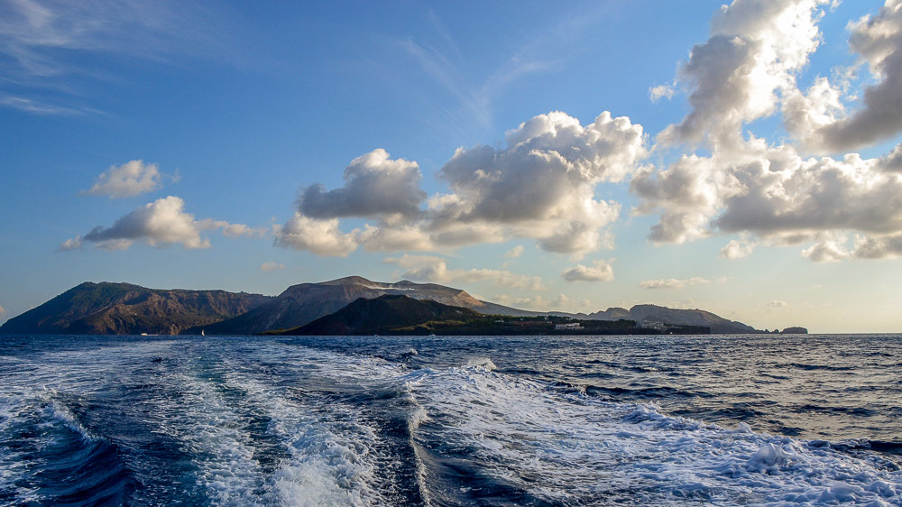The northern profile of Vulcano on which the low Fossa cone is visible (center), the green islet in the foreground is Vulcanello connected by isthmus to Vulcano.