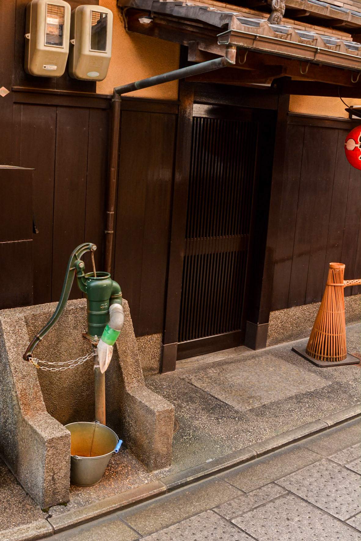 This hand-operated waterpump outside this dwelling is an unusual sight.