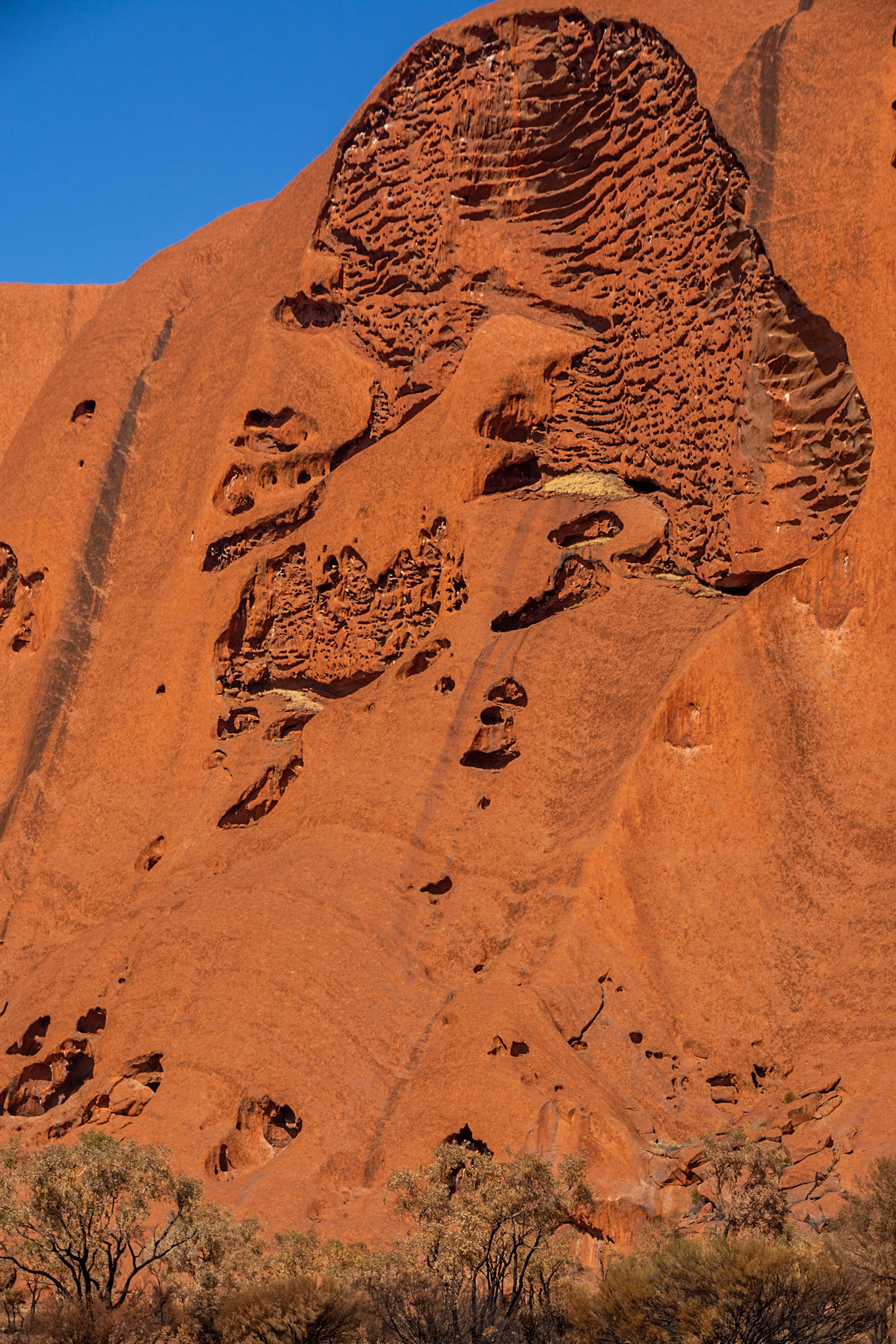 The image of an aboriginal worrier appears etched naturally in the rock face
