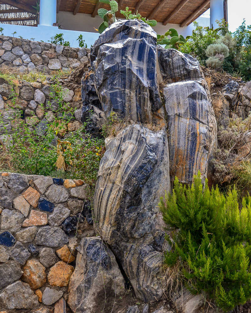Vertical veins of deep blue volcanic glass are a striking feature piece in this landscaped garden.