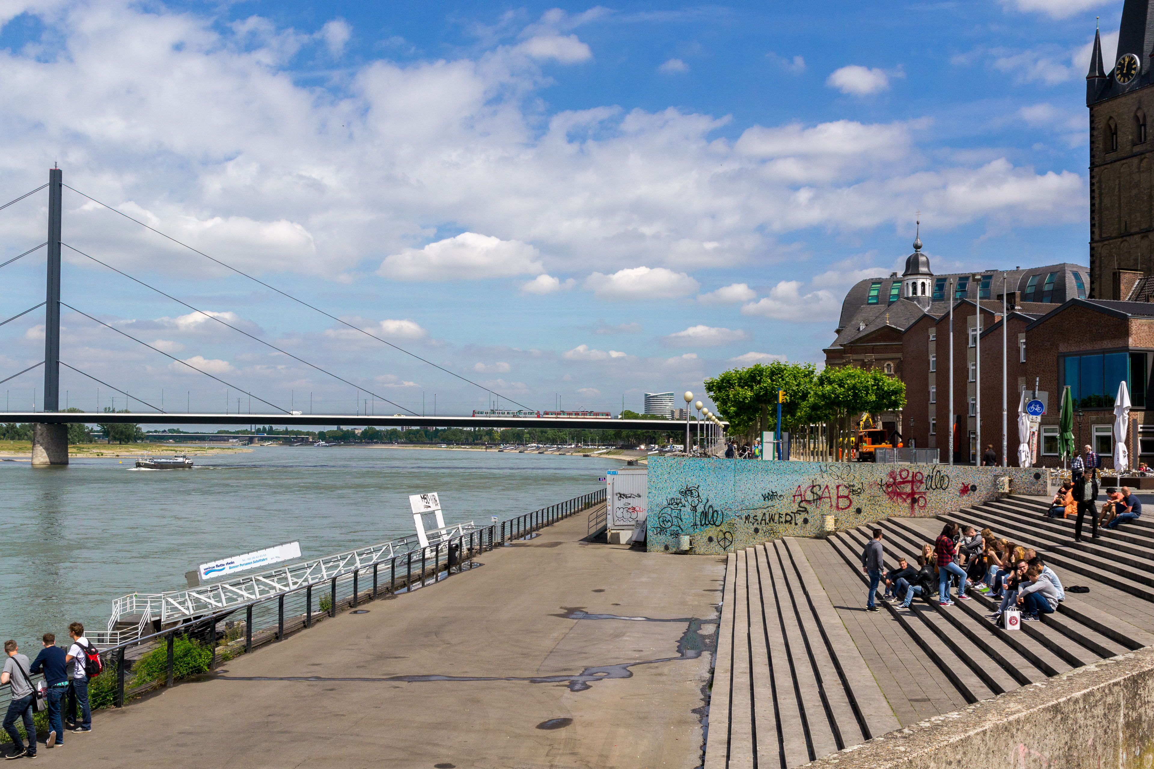 Enjoying the Reinuferpromenade with the Rhine Knee Bridge and St Lambertus church in the background.