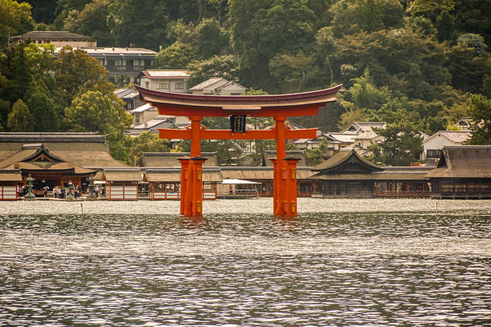 As we approach the island Itsukushima Shrine's famous floating Torii Gate is surrounded at high tide.
