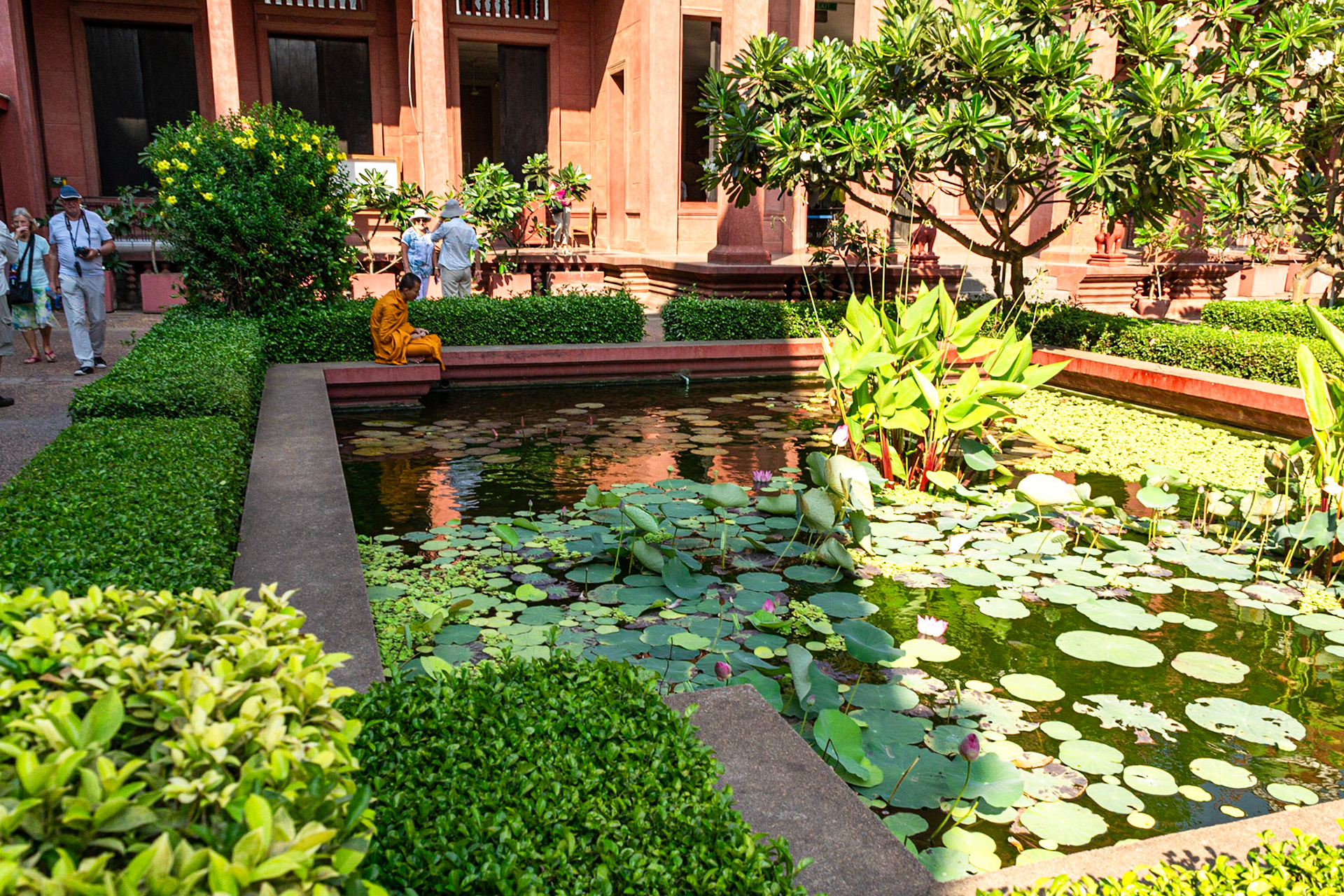 A Buddhist monk relaxes by the cool waters of the lotus pond in the courtyard of the National Museum.