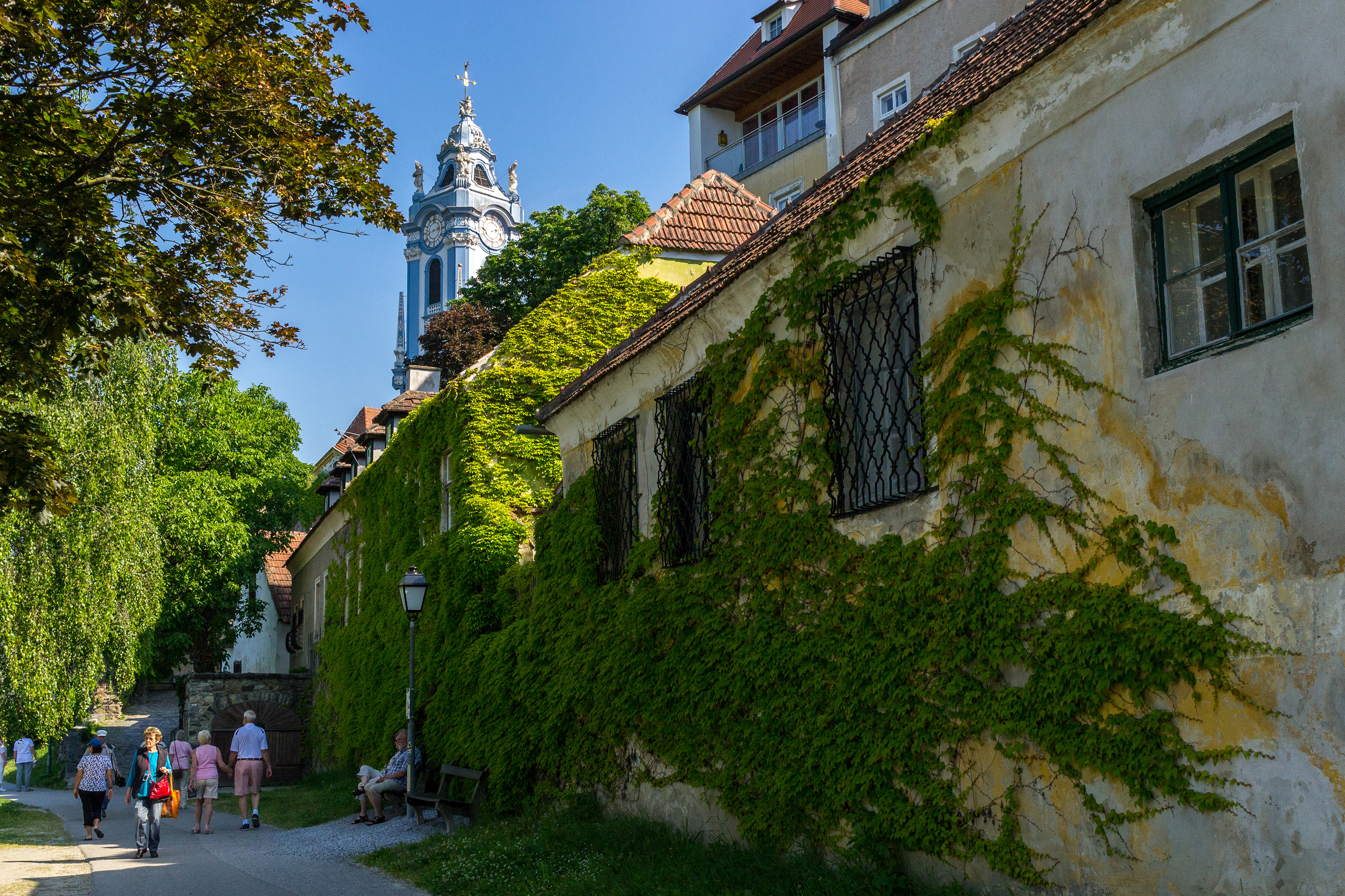 The bell-tower is a visible reference point of the landscape as we enter the village beside ivy covered buildings..