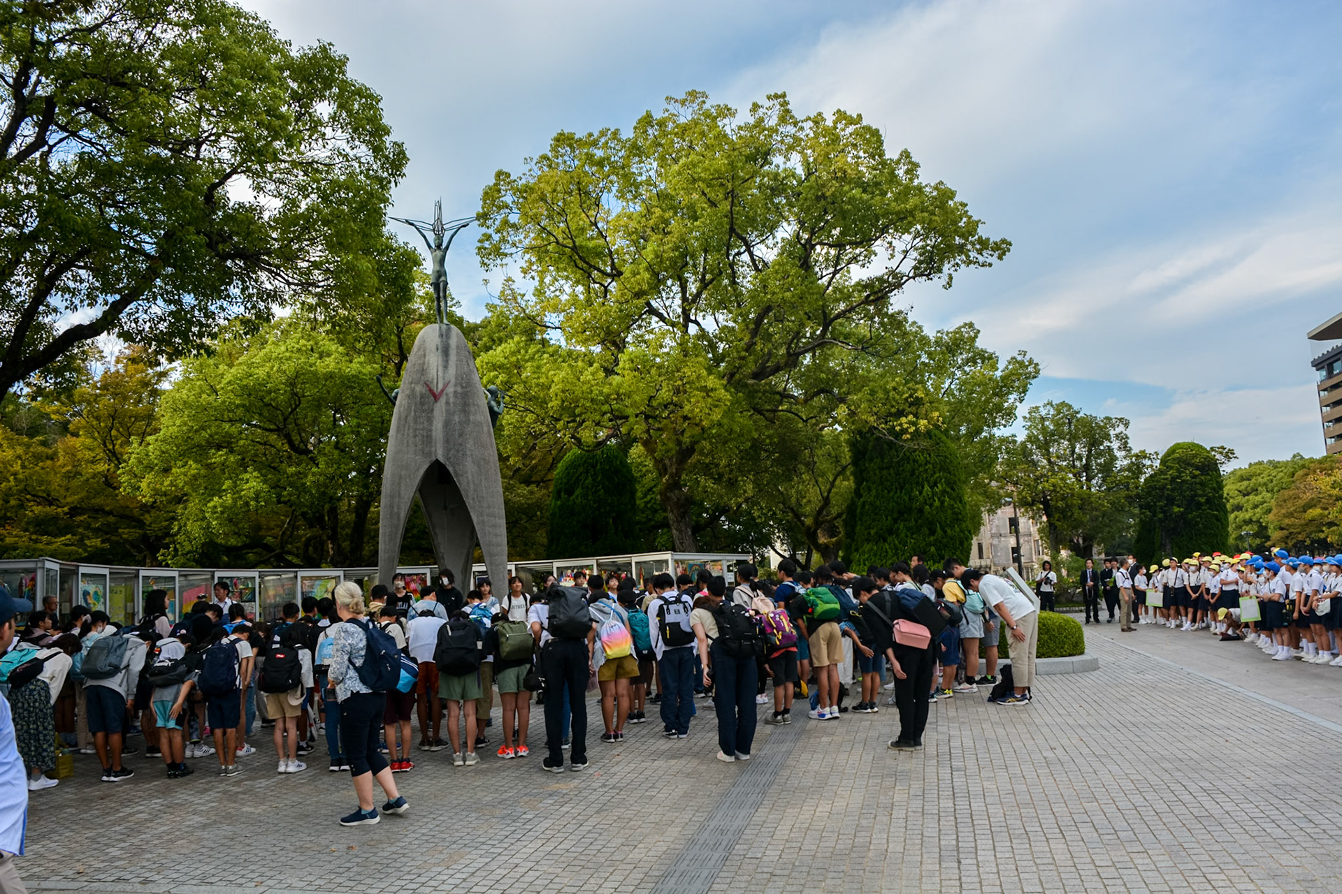 School students and tourists gather to reflect and pay respect at the Children's Peace Monument.