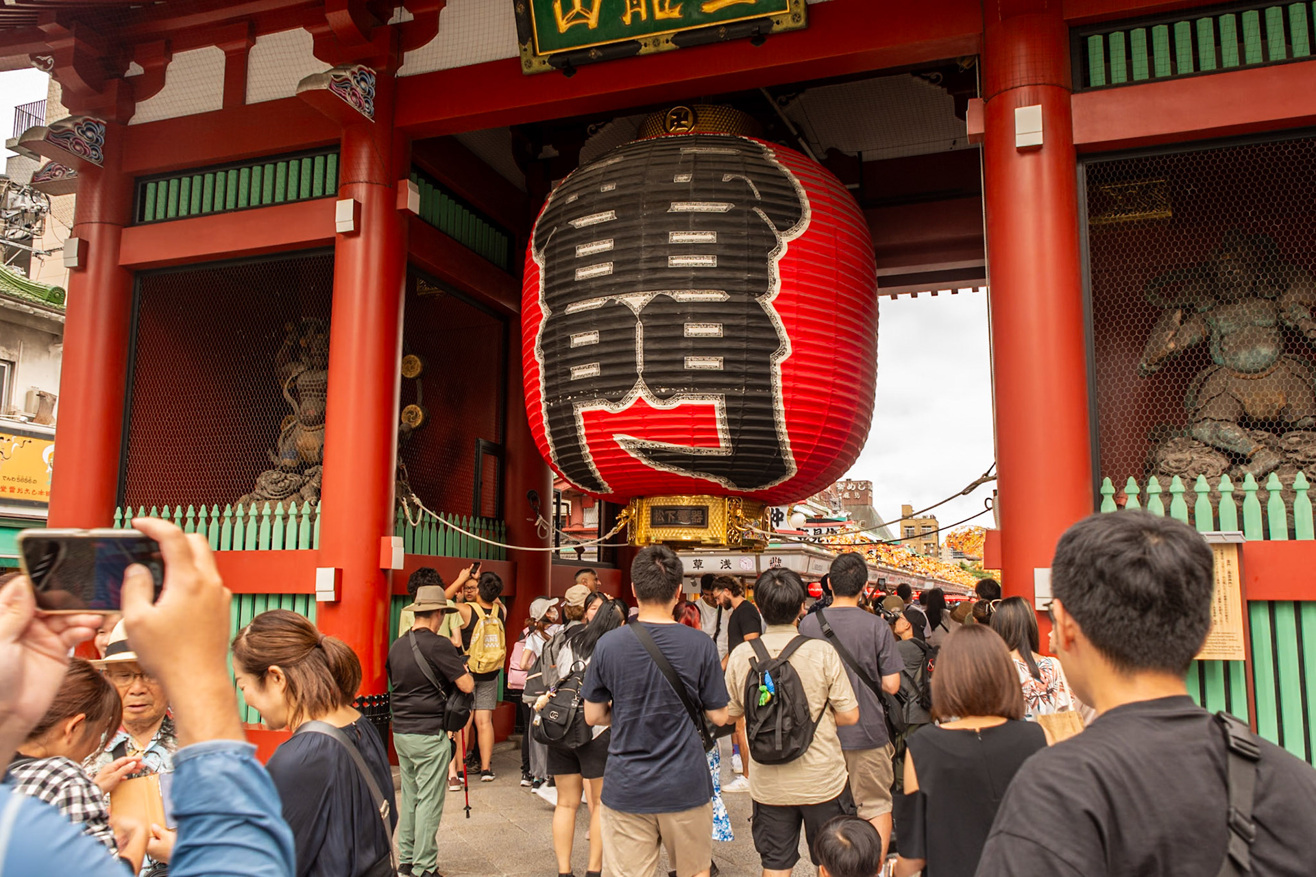 Kaminarimon. A statue of Fūjin (the Japanese god of the wind) stands on the right and that of Raijin ( a god of lightning, thunder, and storms on the left.