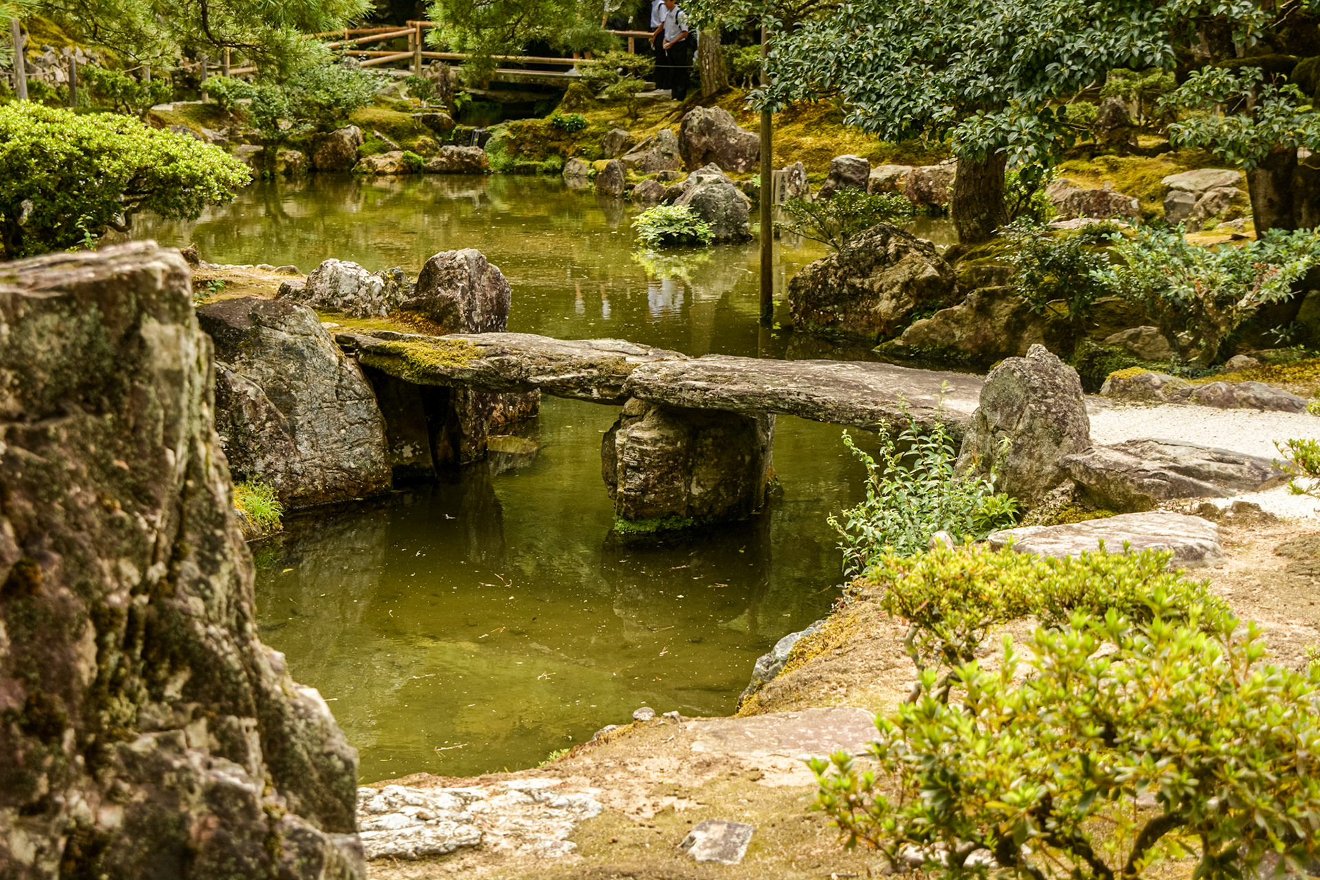 Natural stone is used to bridge the ornamental pond surrounding the silver pavilion.