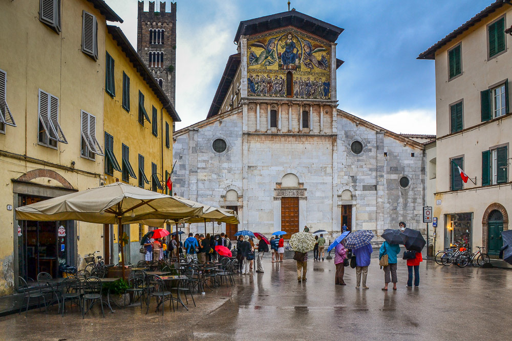 Umbrellas feature as we set out to explore the old city of Lucca, in the background the Bascillica of San Frediano.