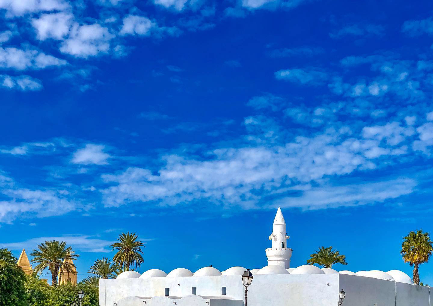 one more family portray of #Multiconfessional #Tunisia's : ocher #church & immaculate #mosque side by side, somewhere around the same #island of #Djerba, captured by Rania Ikbal Ouriemi. Beautiful week ahead! — at Église Saint-Joseph de Djerba