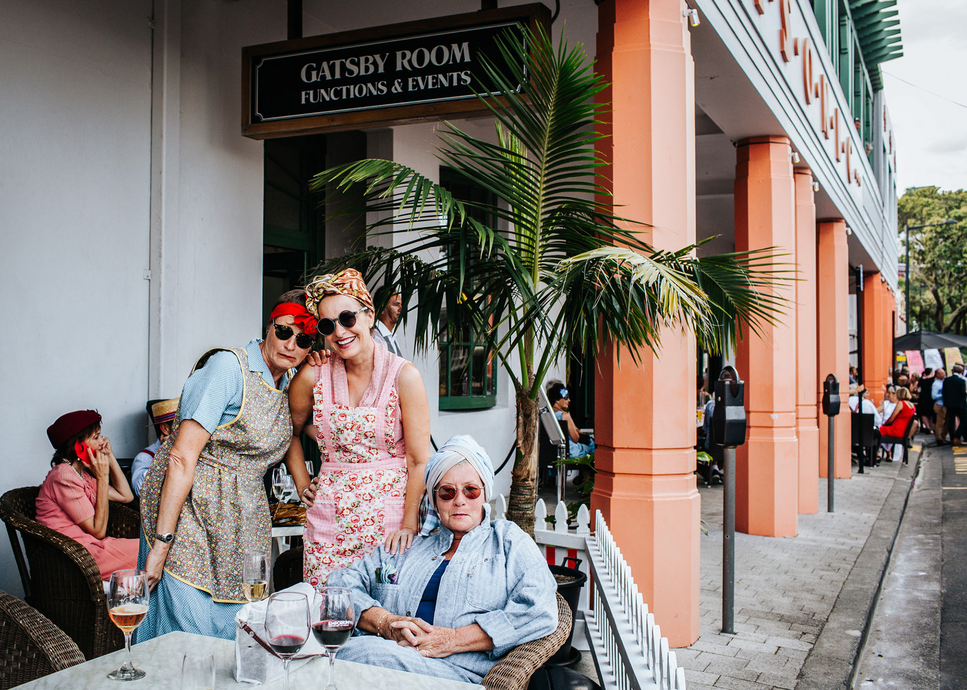 A group of women in art deco costume relax outside the Gatsby Room