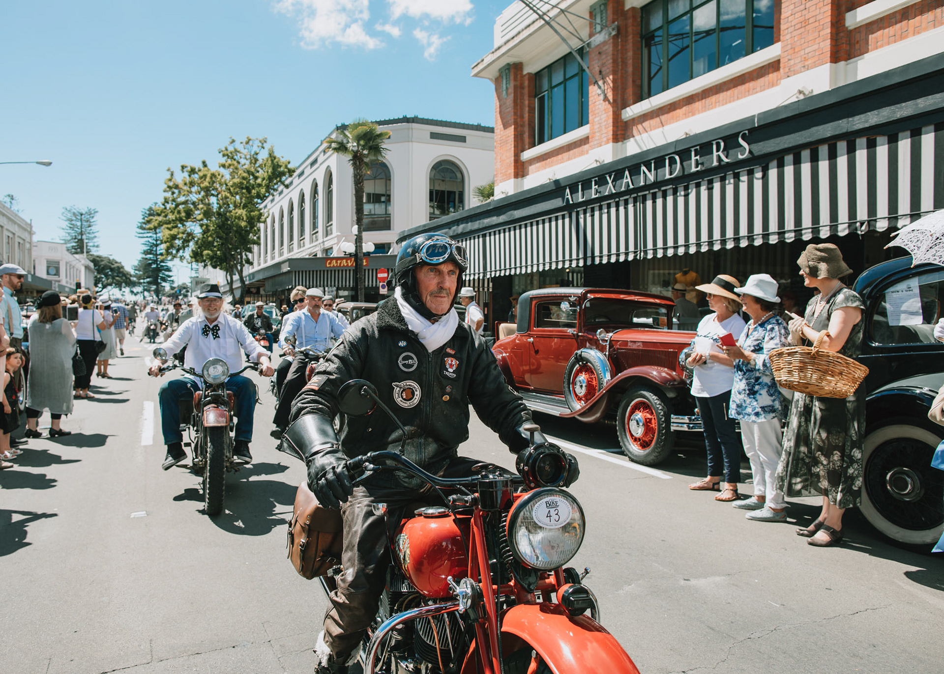 Man on red vintage motorbike during the vintage car parade