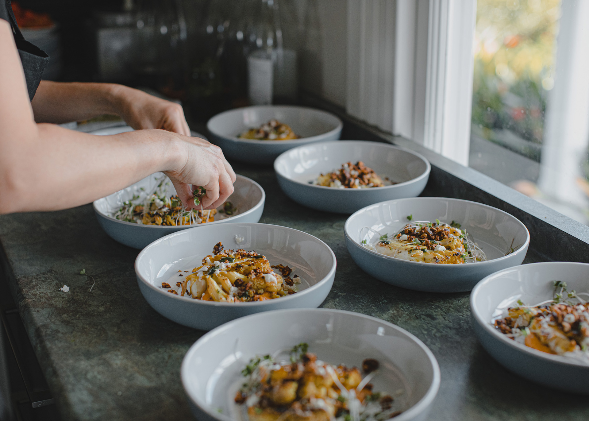 Line up of plates with food being prepared
