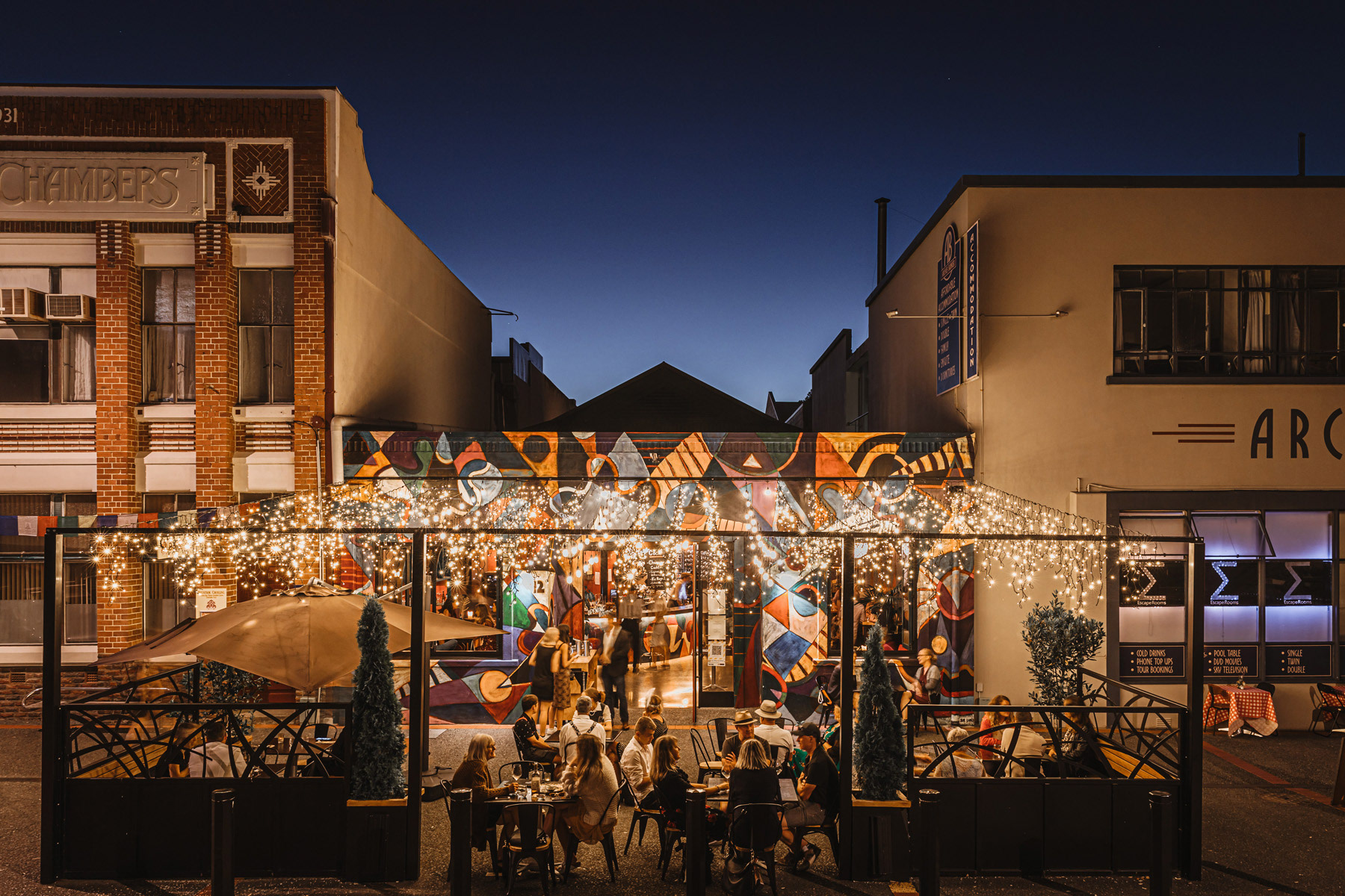 A view of Napier's Matisse Bar alight and colourful at dusk. Venue photographed during the Art Deco Festival event.