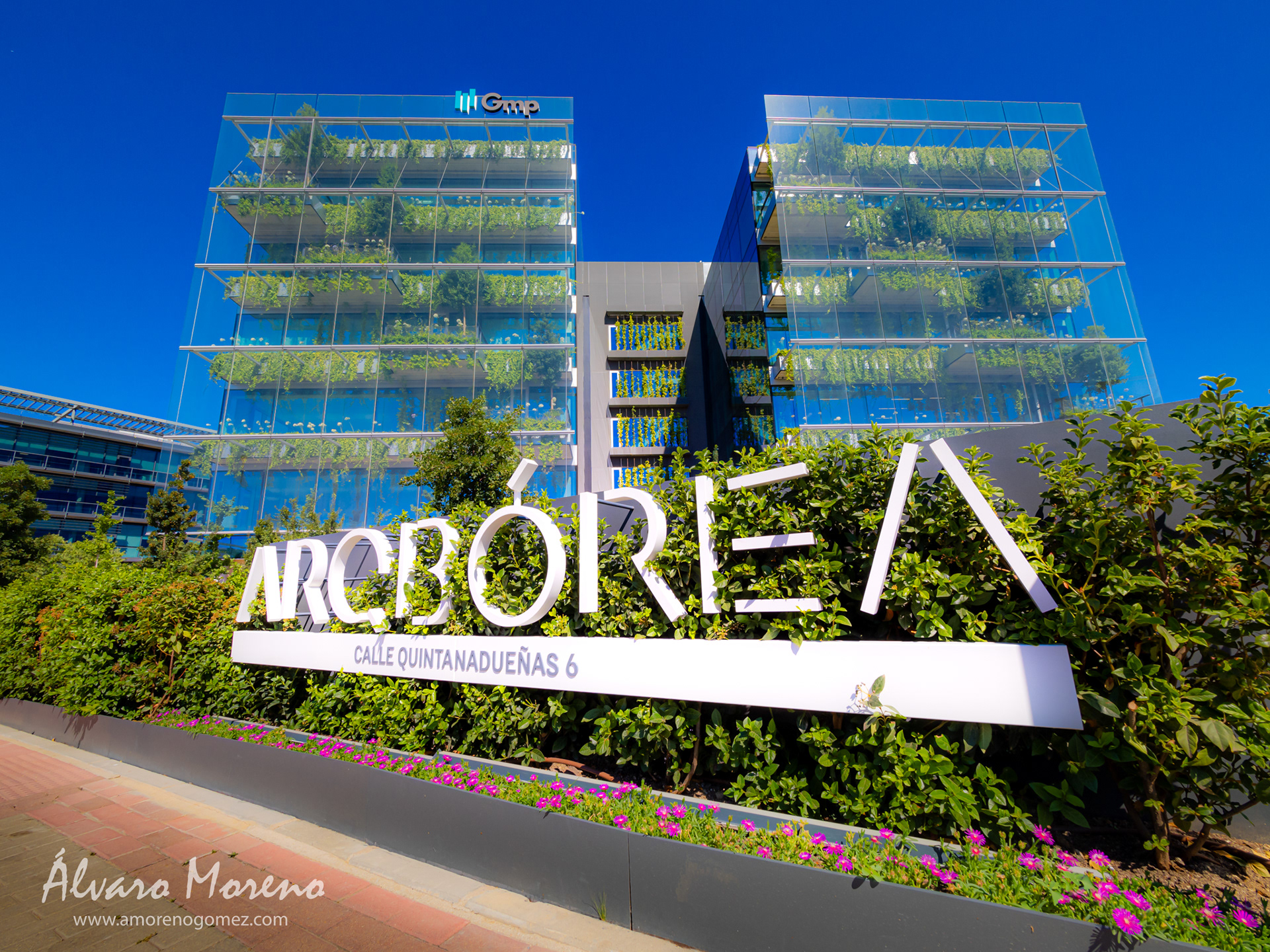 Edificio singular acristalado e integrado con en la fachada con manto verde