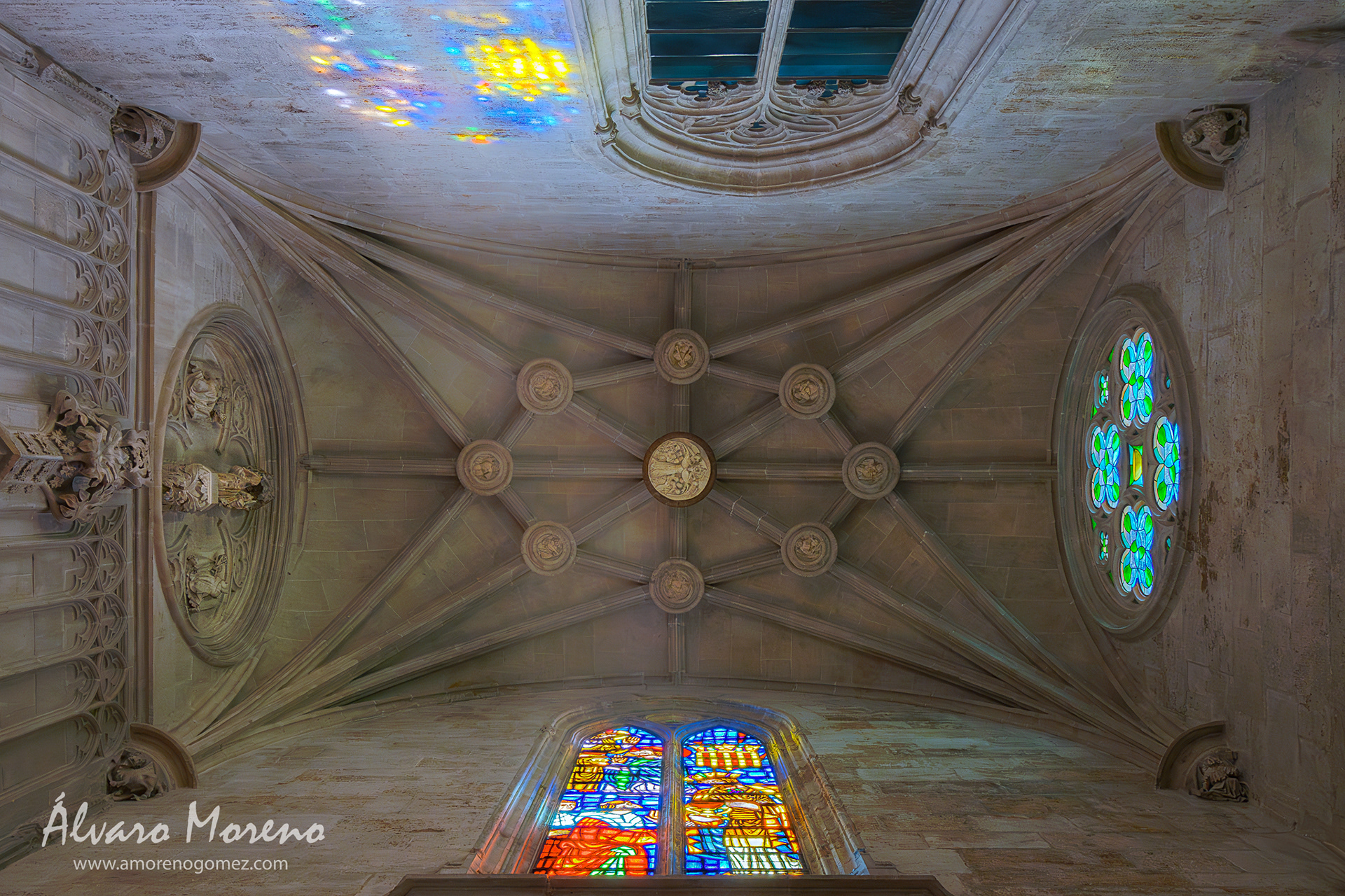 Vista de la bóveda de crucería del pasadizo de entrada a la Capilla del Santo Cáliz, en la Catedral de Valencia, con la vidriera iluminando la pared contraria.