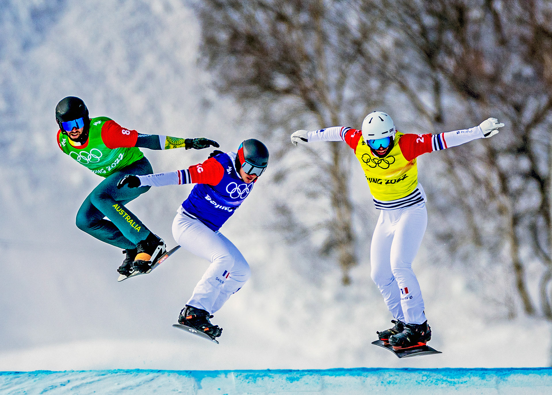 In een decor van besneeuwde boomtoppen vliegen deze drie snowboarders over de laatste helling naar de finish.Foto: Pim Ras