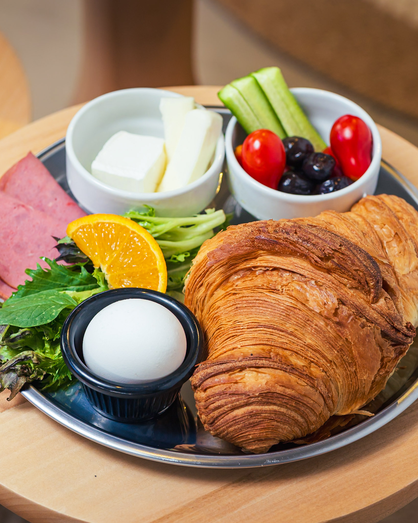 CROISSANT PLATE Our same great croissant served with an egg, white cheese, tomato, olive & smoked beef