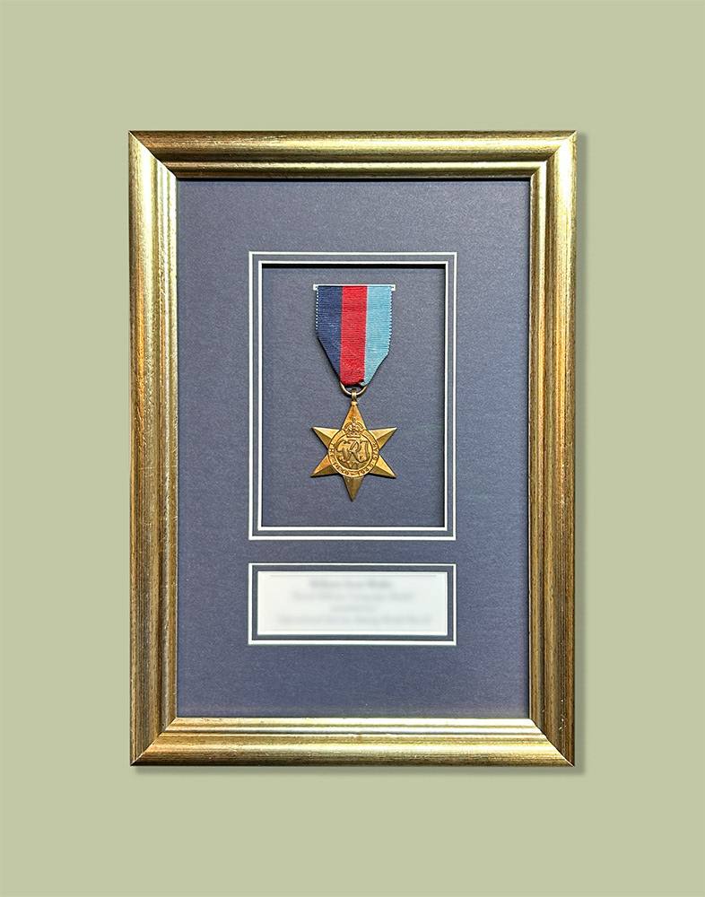 Single War Medal framed with inscription in deep gold-leaf frame and dark blue mountboard and anti-reflective glass