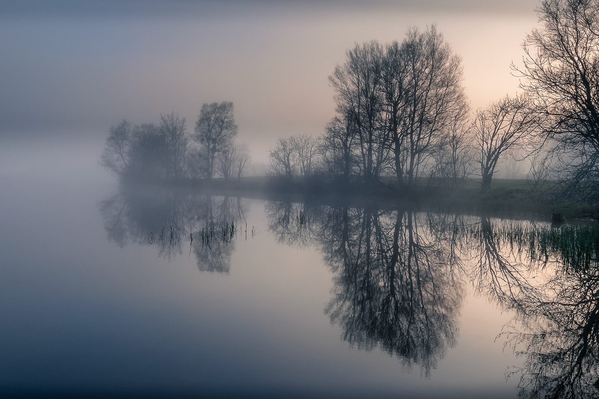 Calm lake in the morning, surrounded with mist