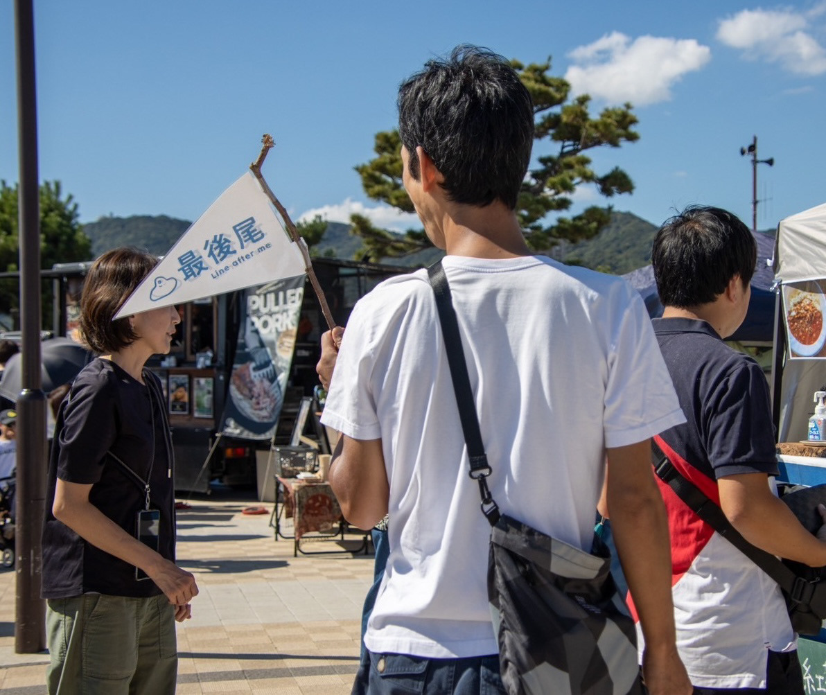 行列の最後の人が持つ最後尾フラッグ
