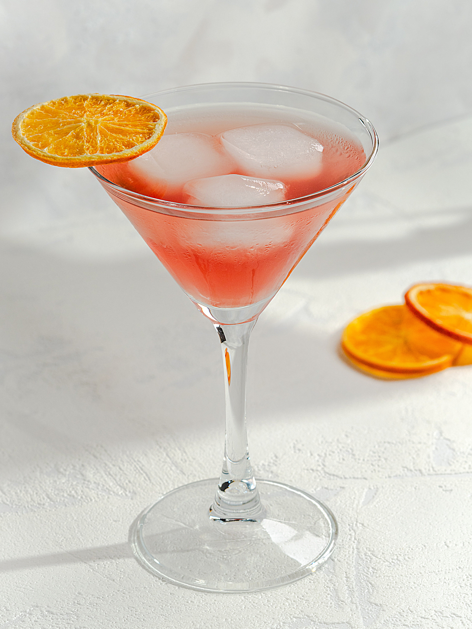 Miešaný nápoj s ľadom a plátkami pomaranča na bielom podklade - Pohľad spredu - Autor Jana Kollarova
