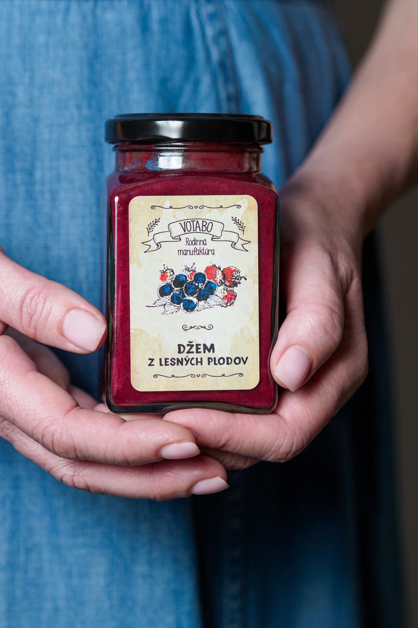 Pohár s džemom v ženských rukách. Pohľad spredu. Autor Jana Kollarova