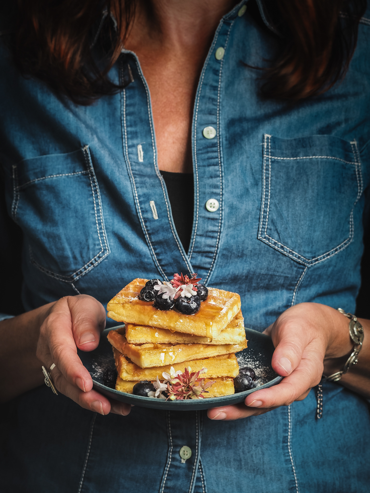 Žena s tanierom vaflí s čučoriedkami. Pohľad spredu. Autor Jana Kollarova