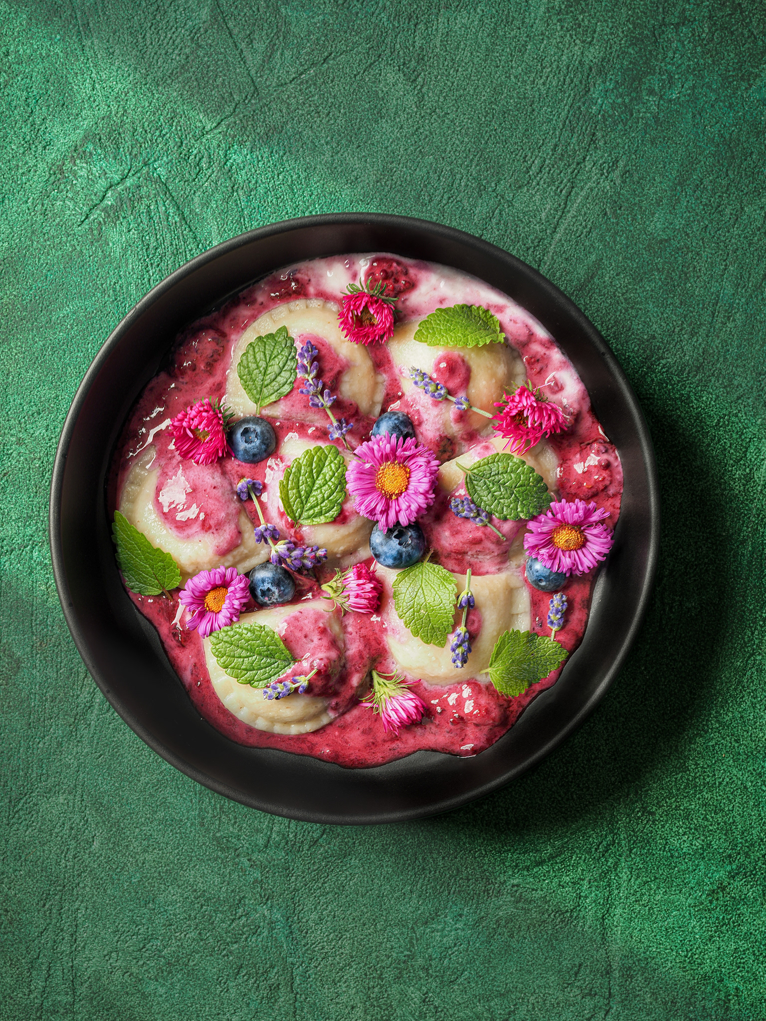 Pirohy s ovocím a jedlými kvetmi na zelenom podklade. Pohľad zhora. Autor Jana Kollarova