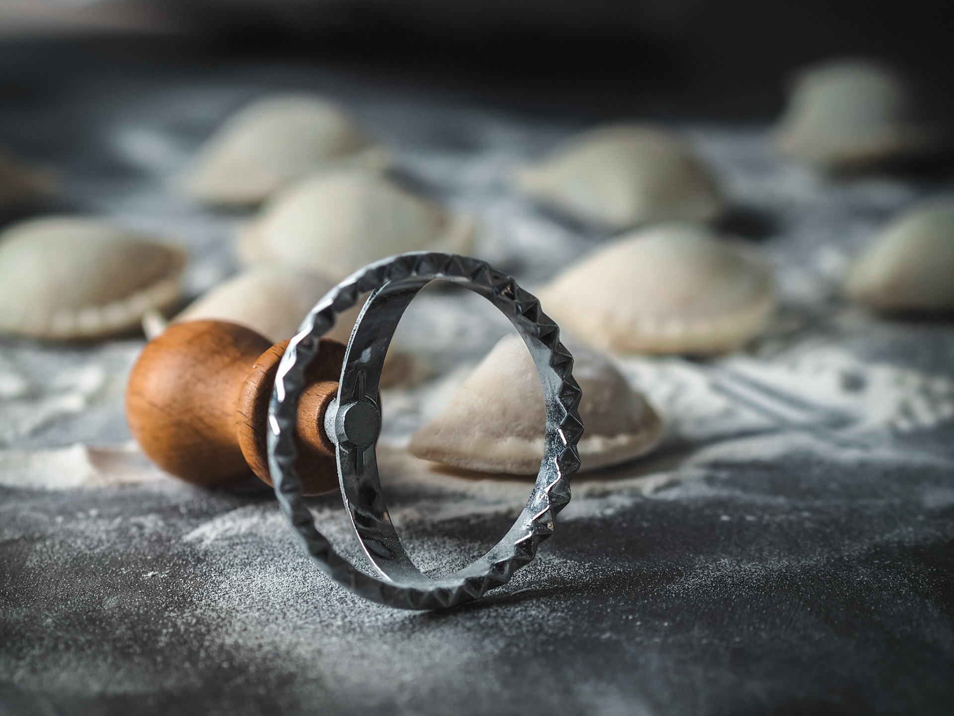 Domáce pirohy a vykrajovač na tmavom pozadí. Pohľad spredu. Autor Jana Kollarova