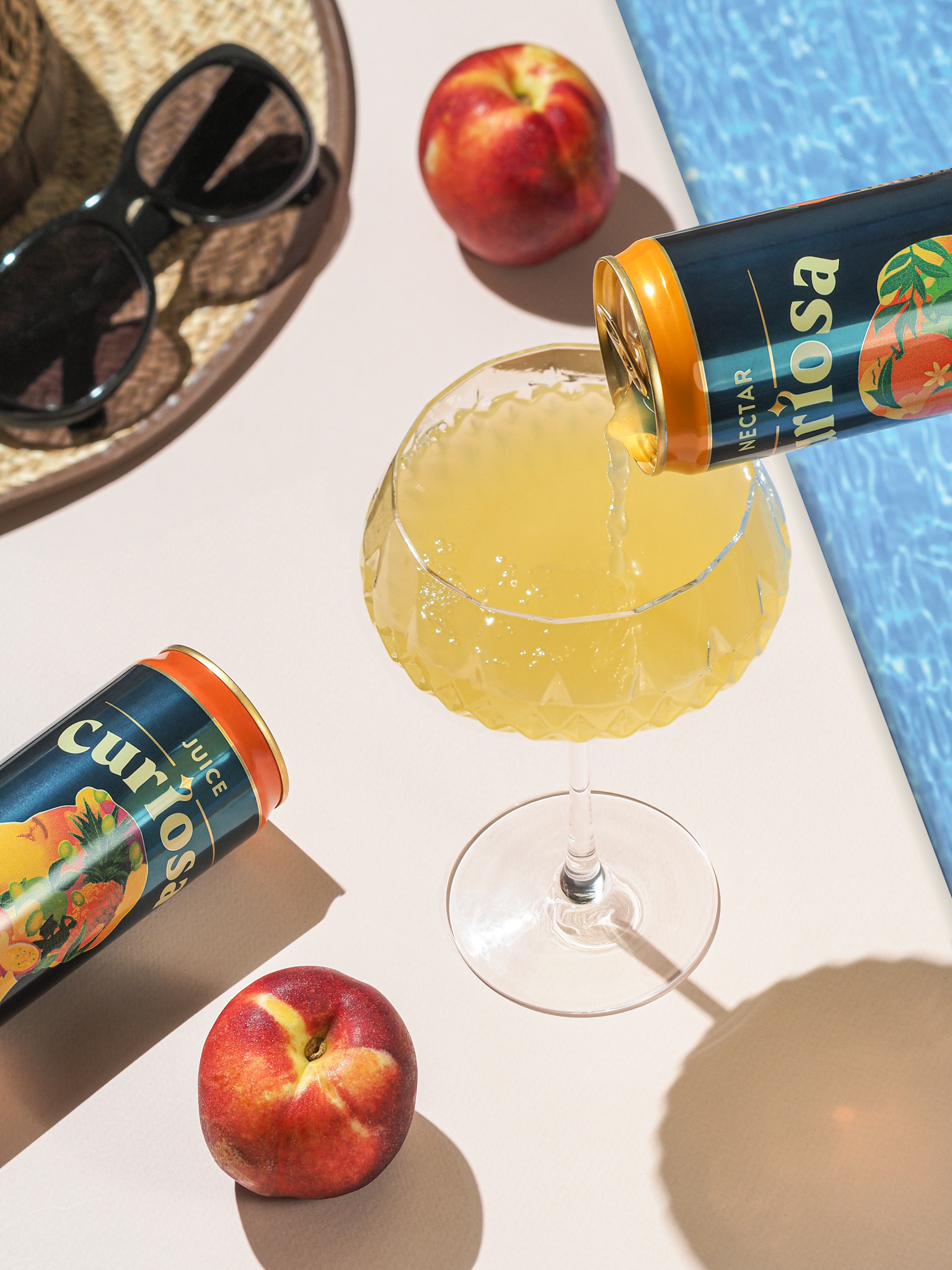 Pomarančový a mulitvítamínový nealkoholický nápoj v plechovke pri bazéne. Autor Jana Kollarova