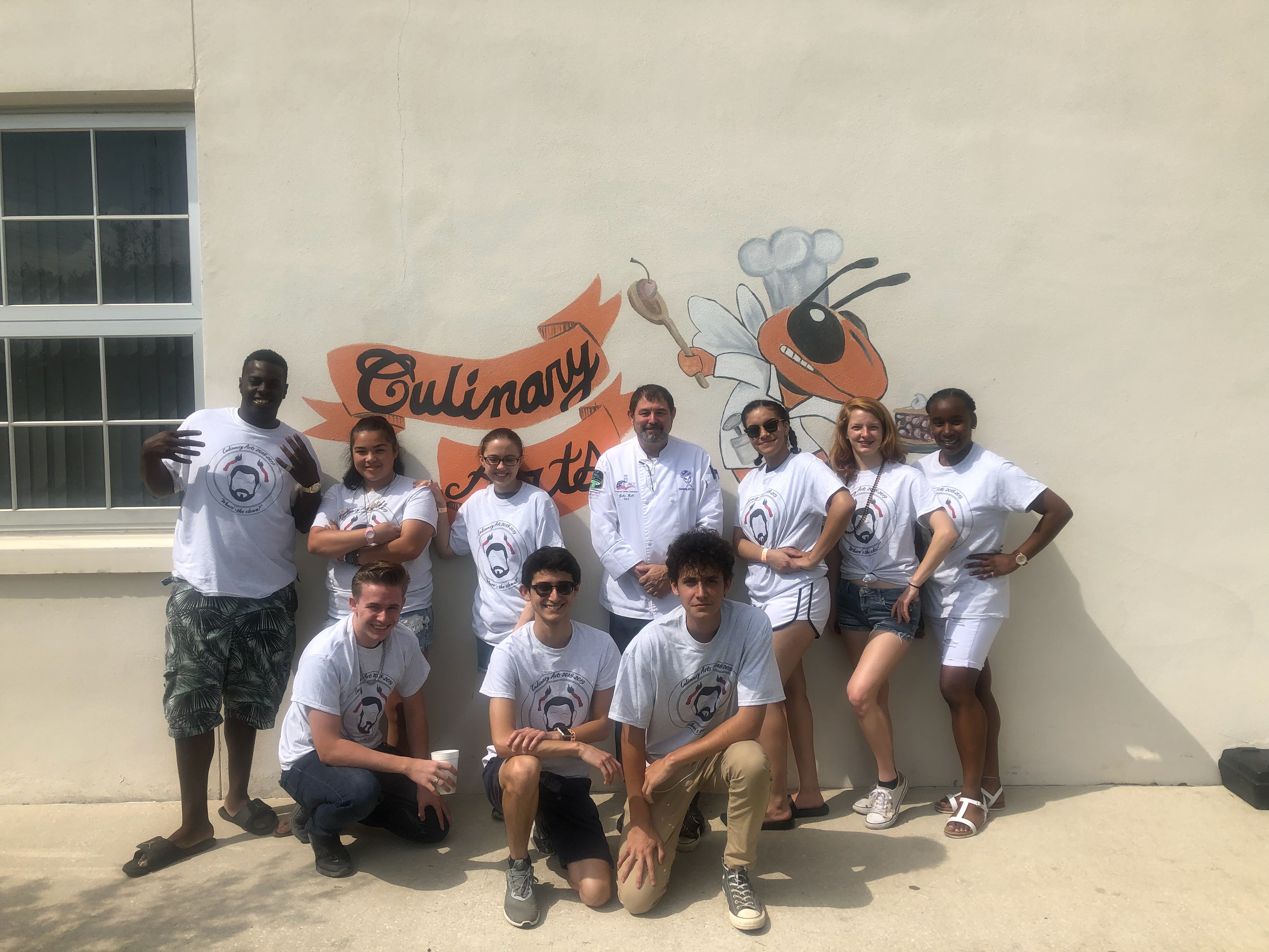 The 2019 Culinary Arts senior class wearing shirts I designed of Chef Bell's face
