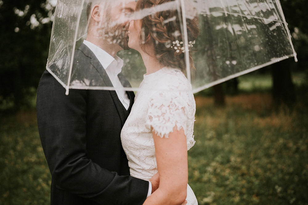 Brautpaar romantisch unter einem Regenschirm