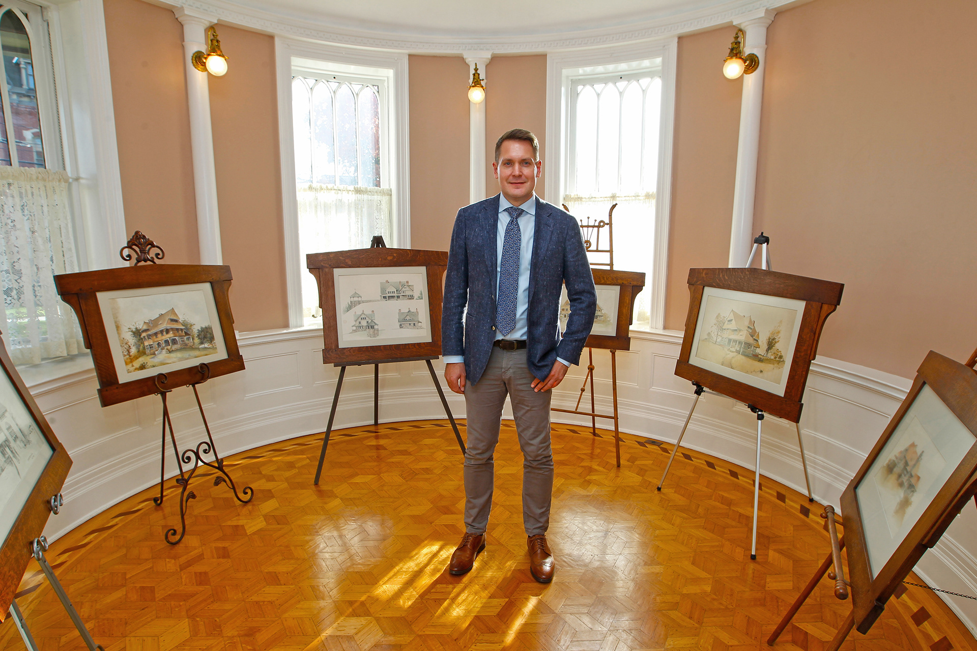 portrait of architect and independent scholar Christopher Jend at the Marvin house with original drawings from the archive of architect e g w dietrich