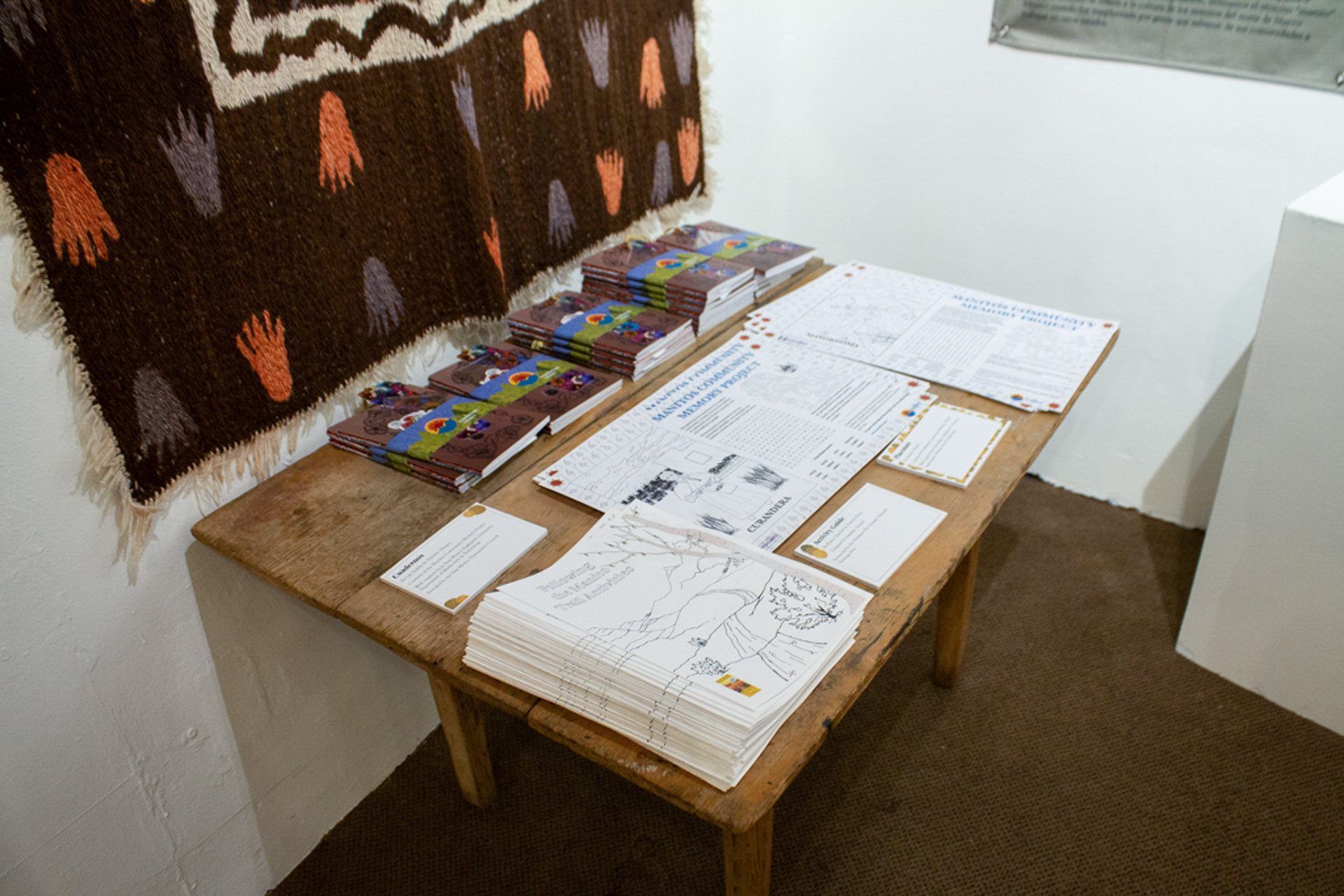 Table with Cuaderno booklets, placemats, and activity guide booklets.