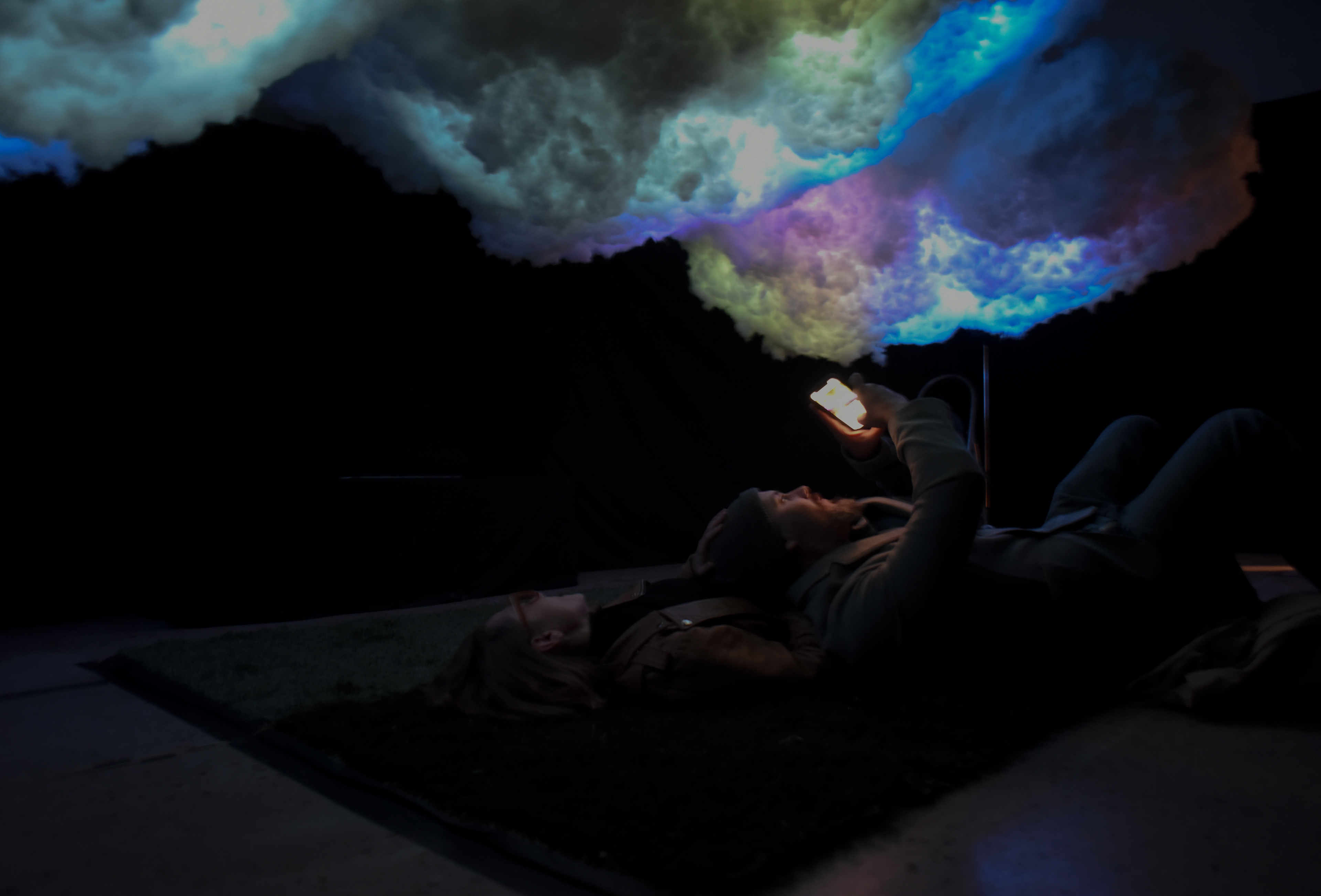 People laying under the cloud looking at the the final product of the cloud