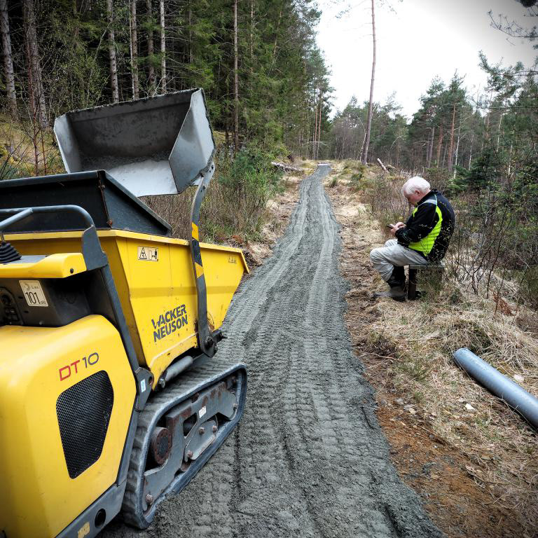 Arne tek ein pust i bakken under arbeidet med Etappe 3 i NATURSTIEN. Foto Anna Gjerde. April 2023.
