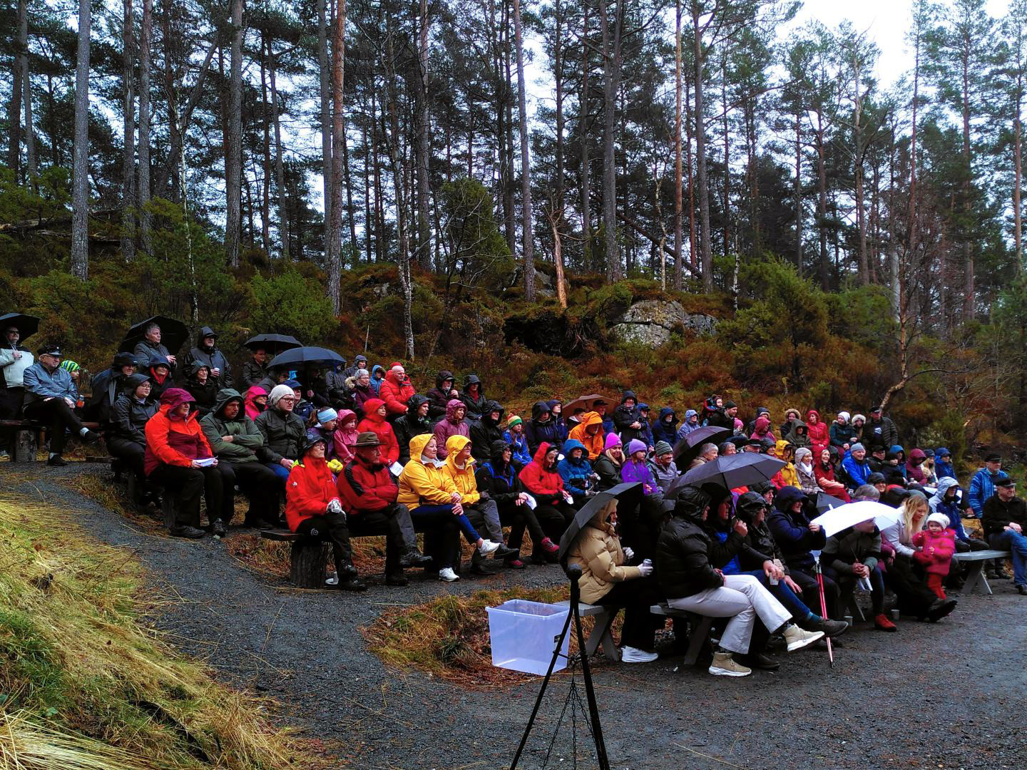 Folket var godt kledde for halvopne sluser frå oven, der dei samla seg oppetter tribunen på konserten.
