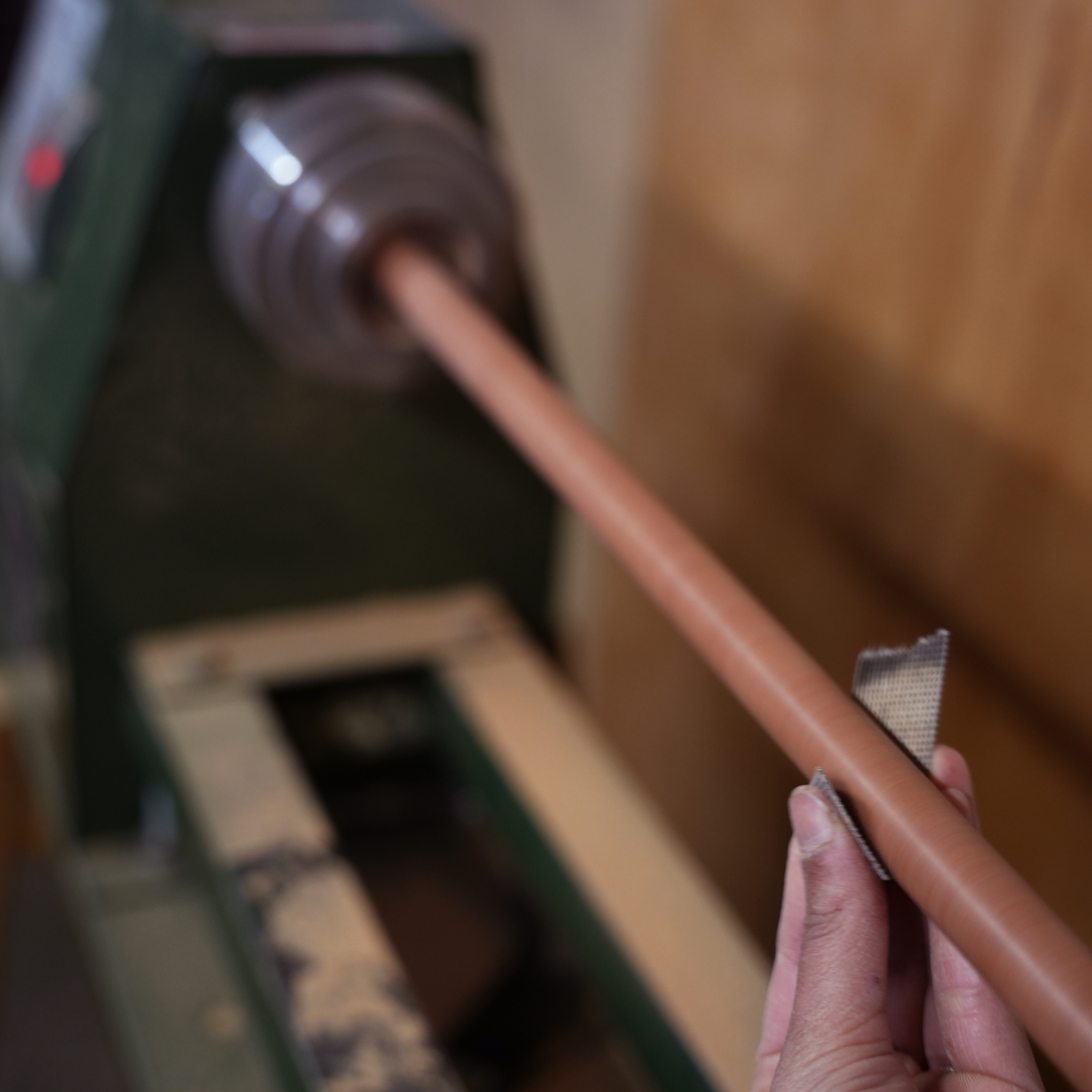 Polishing self-made dowels on lathe.
