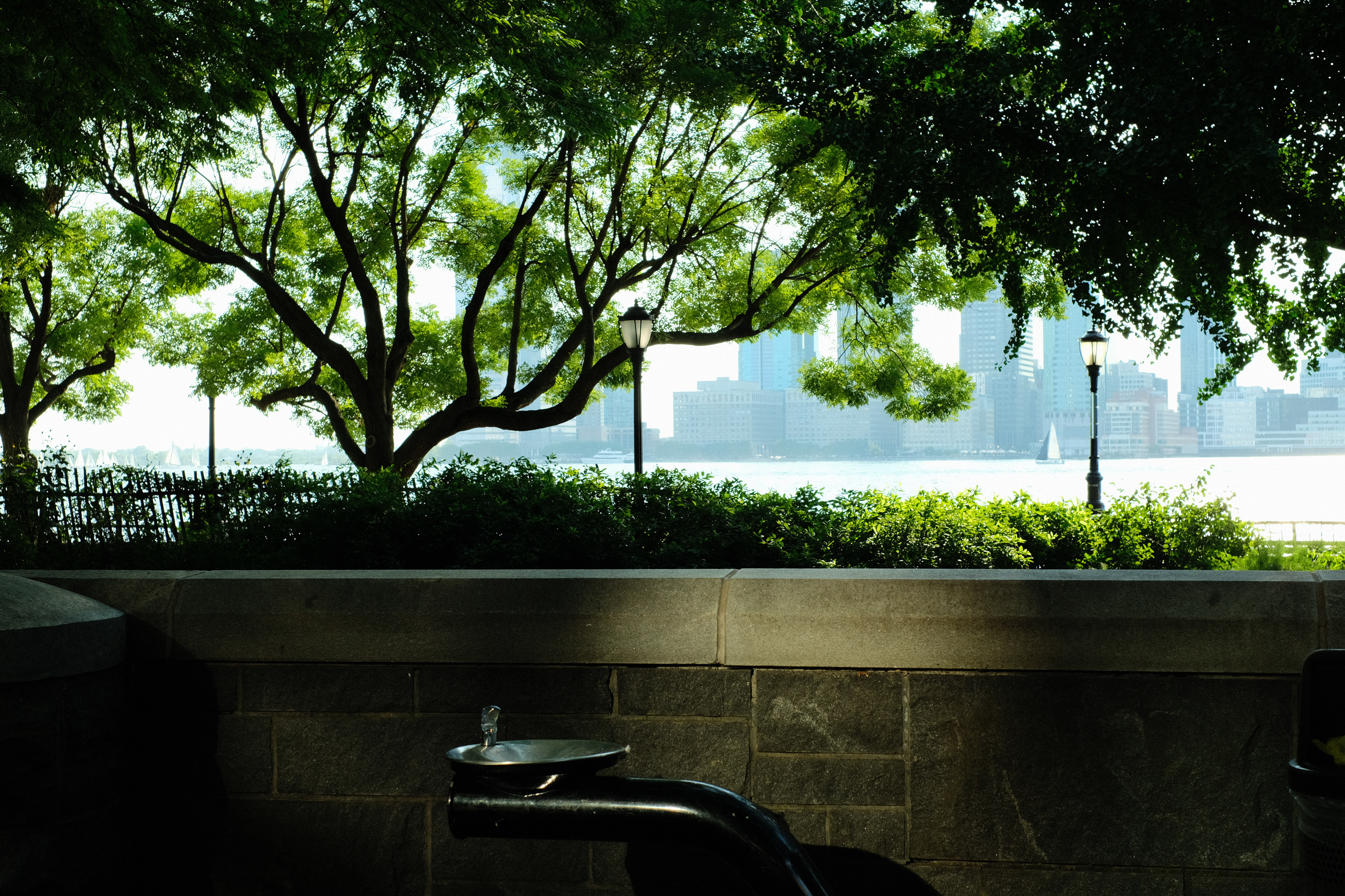 A sunlit water fountain along the Hudson