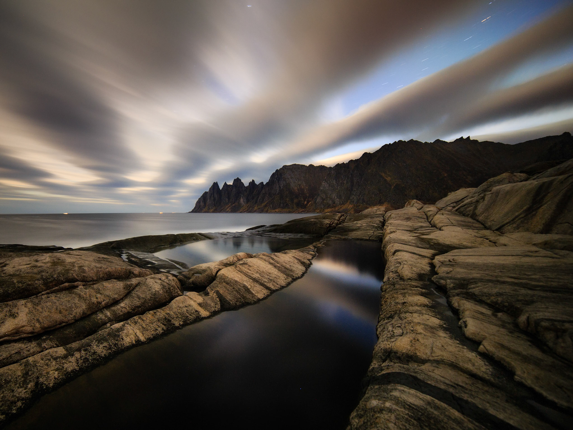 Norway , Dragon Teeth beach, midnight. Subtle traces of Northern Lights showing through the cloud streaks, eerie silence at a completely deserted shore.