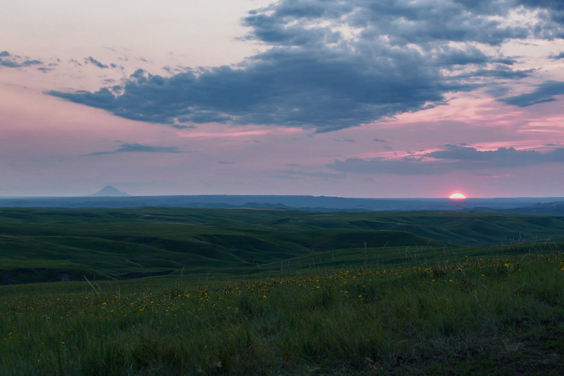 Stopped on the side of a road and got this picture of the sunset and Bear Butte.