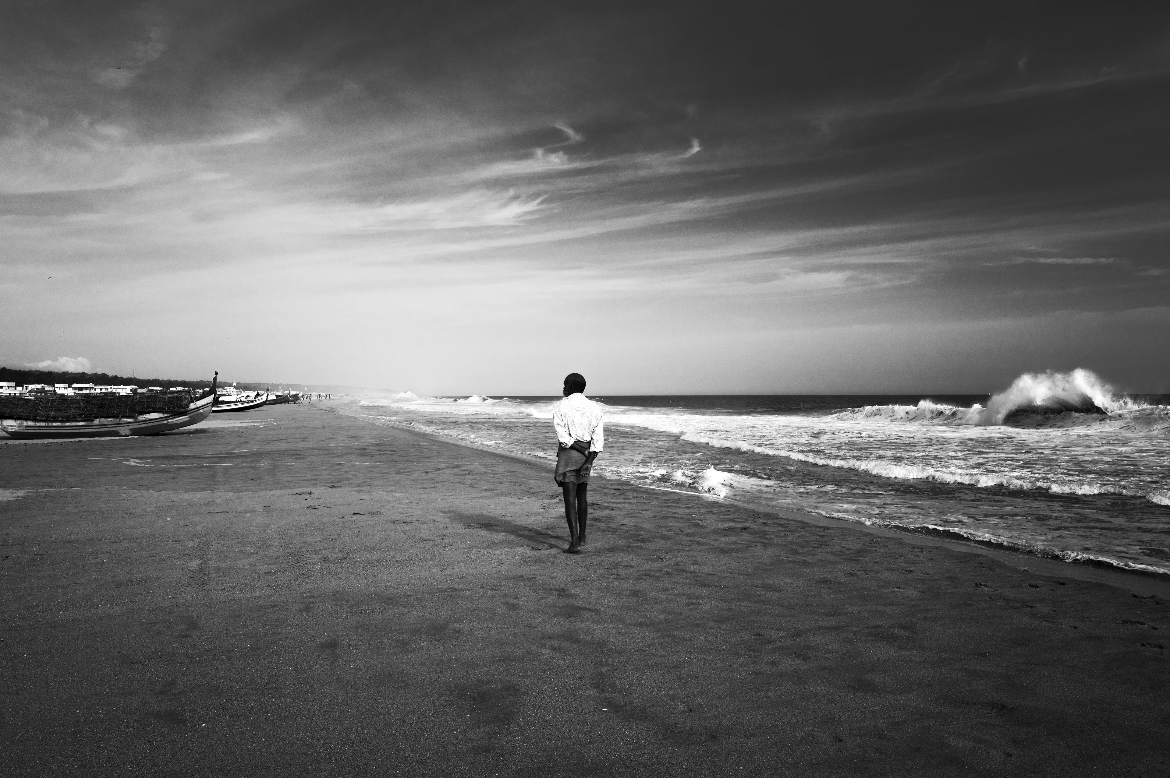 Man walking alone along the coast in Kerala, India