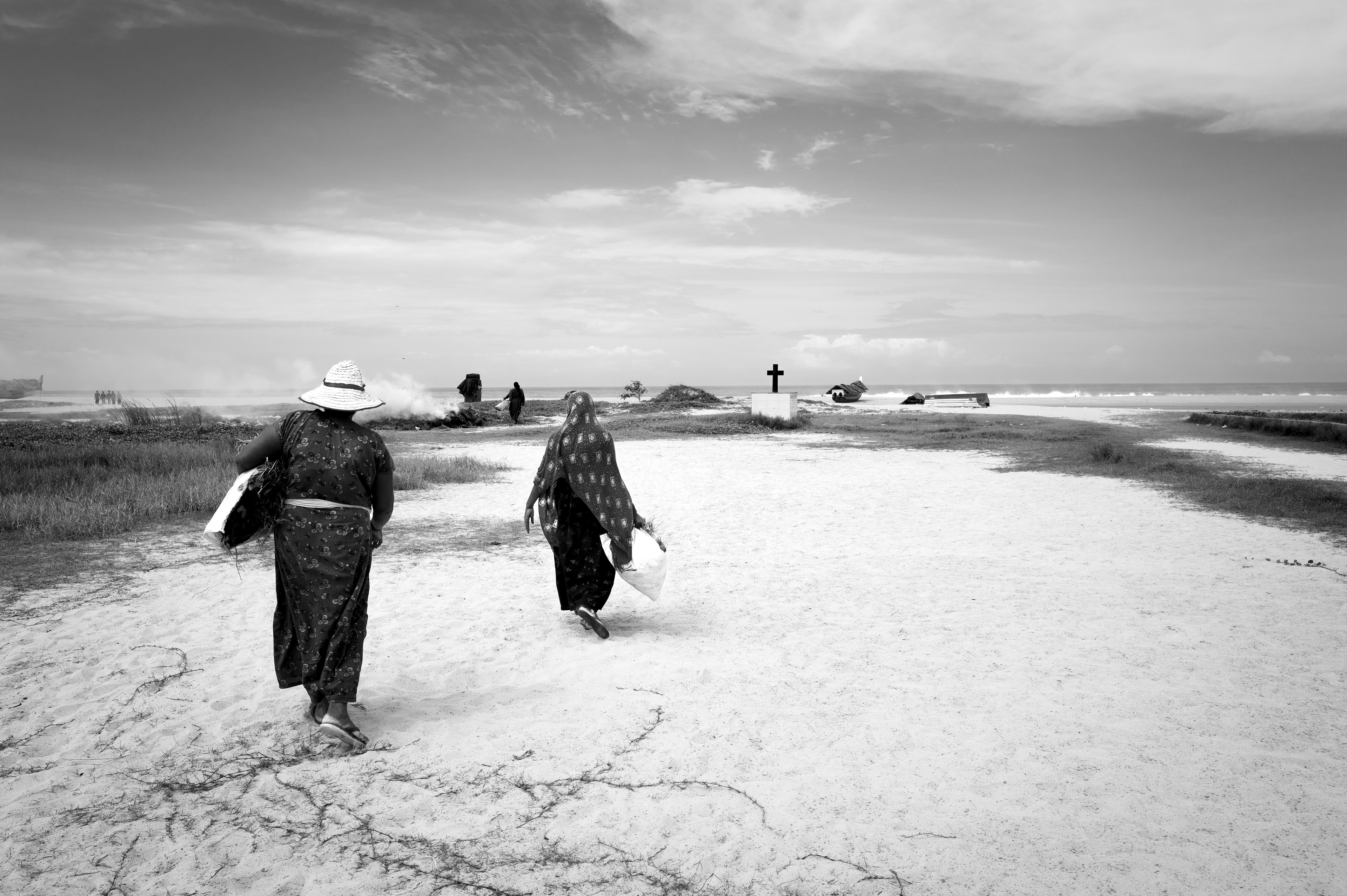 Two women walking along the coast in Kerala, India.