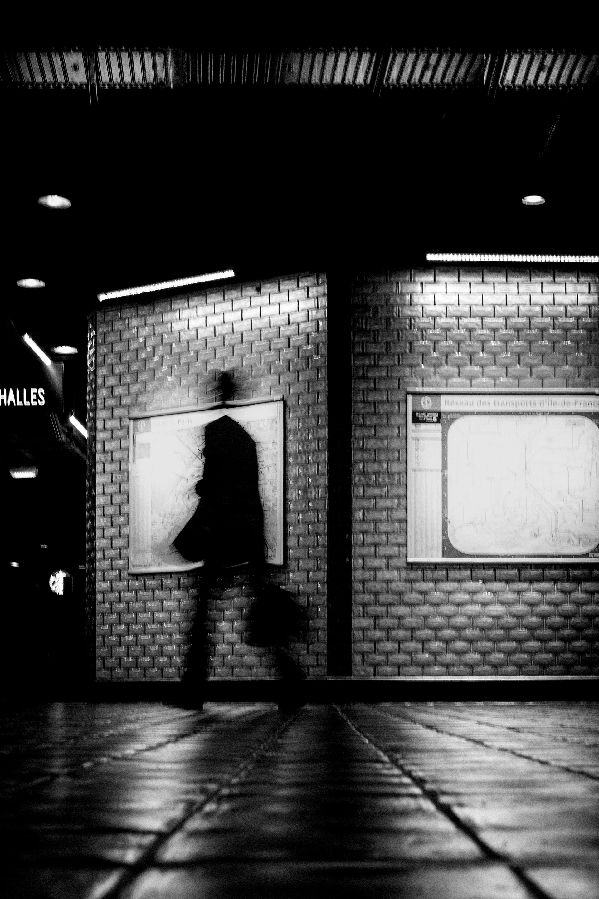 Blurred silhouette inside Les Halles station in Paris.